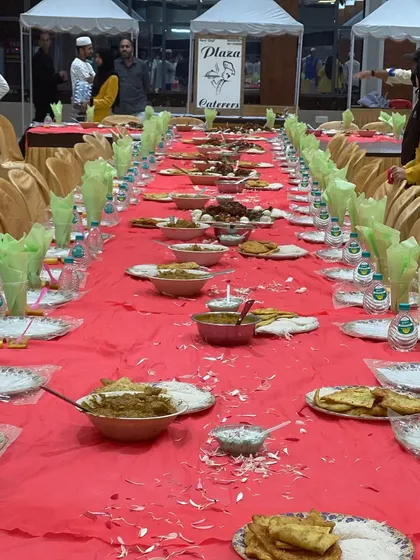 A festive meal setup at the Royal Convention Hall. The tables are beautifully arranged with green napkins and a full spread, ready for guests to celebrate together.