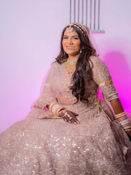 A close-up of Palak's radiant smile. Her makeup is designed to enhance her natural beauty and give her that signature bridal glow.