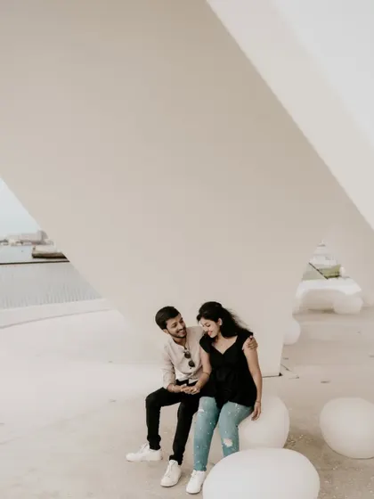 A happy, laughing moment between the couple sitting on modern white orbs.