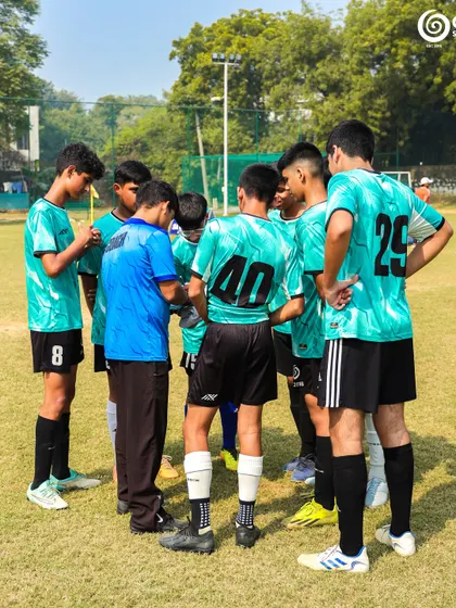 A coach gives instructions to his U-15 team during a huddle. Team strategy is key at this level.