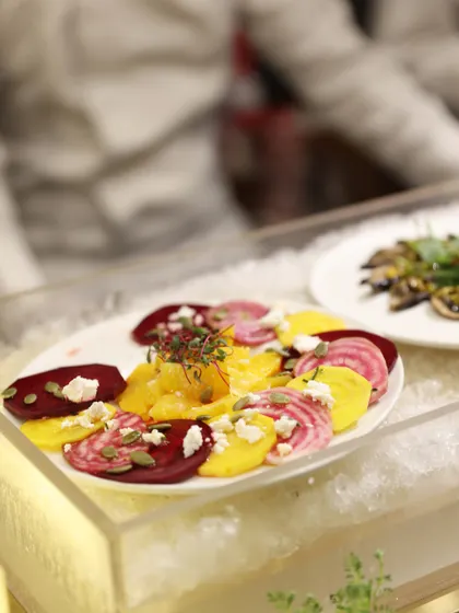 A colourful salad of sliced heirloom beetroots and oranges, with crumbled cheese and seeds. We use the freshest seasonal ingredients to create salads that are both healthy and visually stunning.