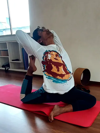 A student practices Eka Pada Rajakapotasana, or One-Legged King Pigeon Pose. This deep backbend and hip opener is a beautiful expression of transforming the body to find inner stillness.