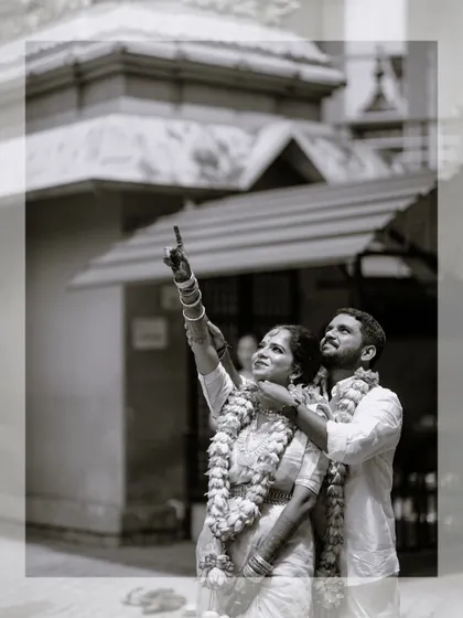 A classic black and white portrait of the couple in a hopeful pose, looking towards their future together outside a traditional temple.