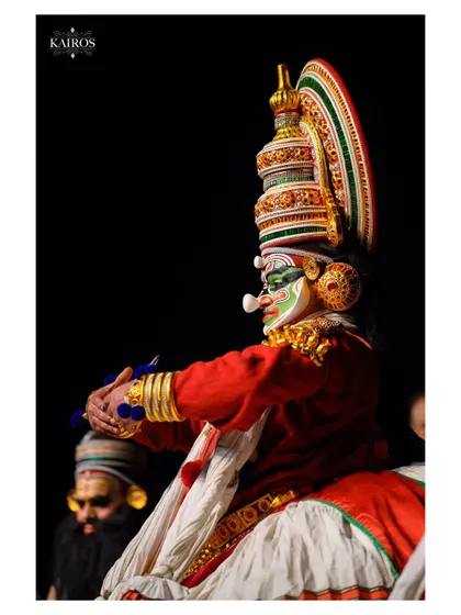 A similar shot to the previous one, emphasizing the unique silhouette and ornate details of the Kathakali performer's attire.