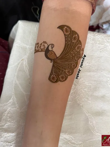 A detailed shot of the elegant peacock motif created for this engagement bride, showcasing the fine lines and floral details in its feathers.
