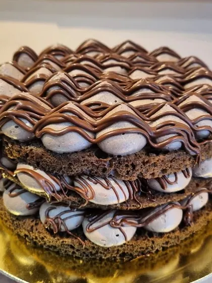 The Nutella Mousse Cake is pure heaven on a plate. This eggless dessert has a chocolate cake base layered with light chocolate mousse and a rich Nutella topping.
