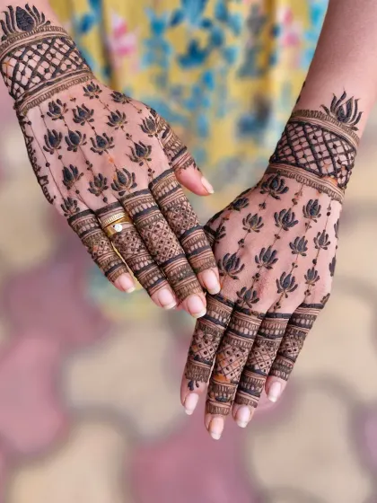A modern and elegant design featuring a pattern of bold lotus motifs. This Indo-Arabic style is perfect for clients who want a contemporary yet meaningful mehendi, with detailed work on the fingers.