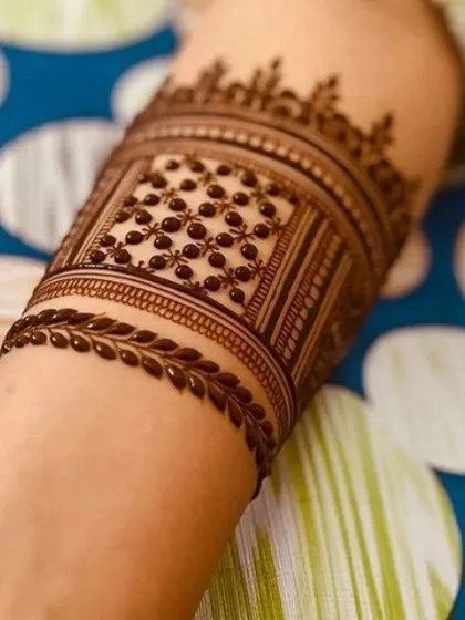 A close-up of the armband, highlighting the delicate leaf border and the perfectly executed dot work inside.