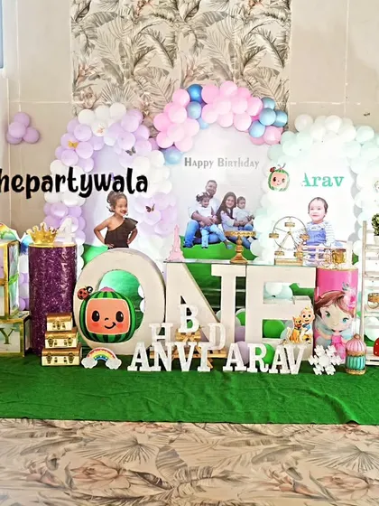 A large-scale Cocomelon theme with a green turf floor and multiple character cutouts.