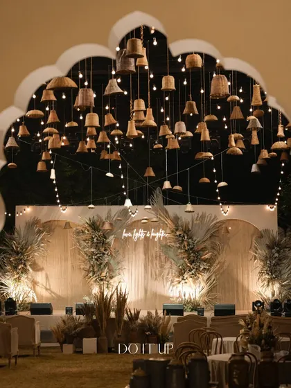 A full view of the sangeet stage, framed by the heritage architecture of the venue. The warm lighting and natural textures of the decor created an inviting and stylish atmosphere.