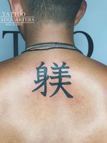 A clean and bold tattoo of Chinese characters on the upper back.