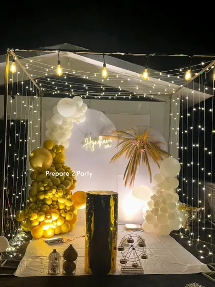 We can transform any terrace into a stunning party space with our lighted cabana frame. This setup features elegant white and gold balloon decor, a custom neon sign, and delicate fairy lights, creating a cozy and luxurious ambiance for an intimate celebration.