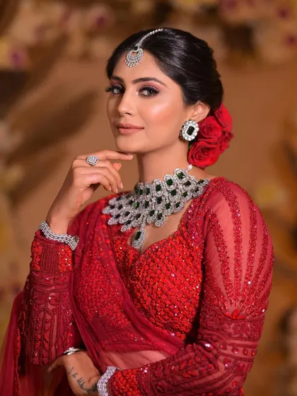 A portrait of a stunning bride in red. The makeup is glamorous and bold, perfectly suited for a bride who wants to make a statement on her wedding day.