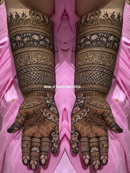 A classic band-style bridal mehendi. This design features structured layers of traditional patterns, including florals and jaali work, creating a look of perfect symmetry and rich detail.