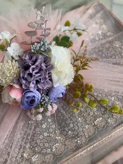 A close-up of the floral arrangement on our trousseau packaging, showing a mix of purple, blue, and white flowers.