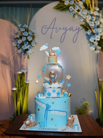 A stunning multi-tiered cake with a teddy bear theme, perfectly matching the blue and white decor of the baby shower.