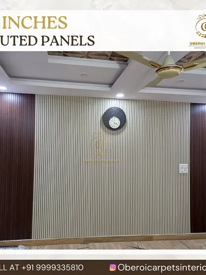 This living room wall features a combination of light-colored 12-inch fluted panels in the center, bordered by dark wood-finish panels. This two-tone design adds contrast and creates a defined space for a clock or artwork.