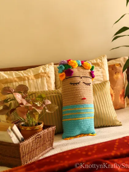Another view of the Frida cushion, perfectly at home among other pillows on a cozy bed. It’s a piece that invites you to rest and dream.