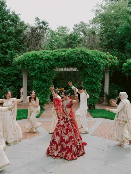 A wedding day is about celebrating with your loved ones. This shot captures the bride dancing with her bridesmaids, showing how a well-fitted lehenga allows for comfort and movement.