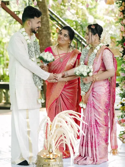 A moment of blessing during the ceremony, with a family member joining the couple's hands.