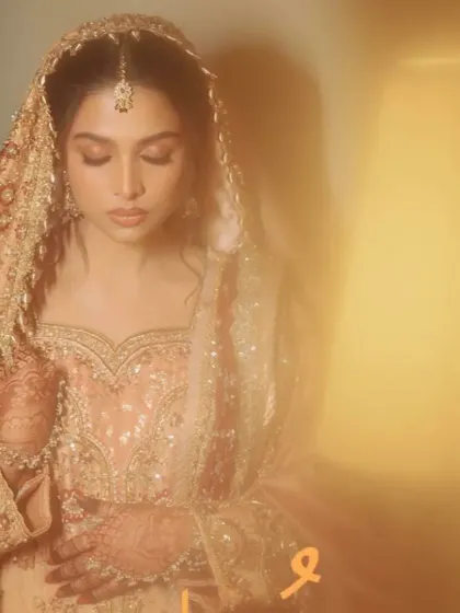 An artistic, dreamy shot of the bride in her magnificent peach and maroon bridal attire.
