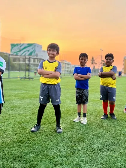 Happy smiles at our club! A group of our youngest players enjoying their time on the field under a beautiful sunset.
