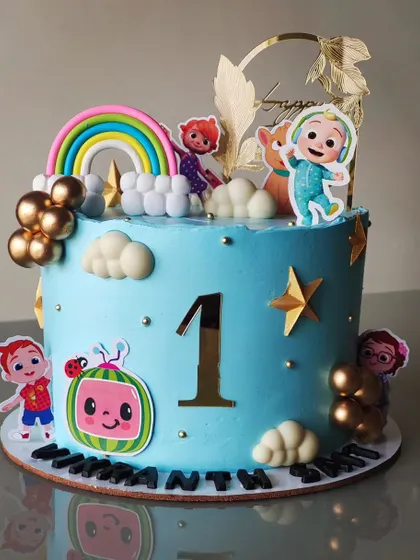 This Cocomelon cake is perfect for a first birthday party. The bright blue cake is decorated with a rainbow, clouds, stars, and all the favorite characters for a cheerful and fun celebration.