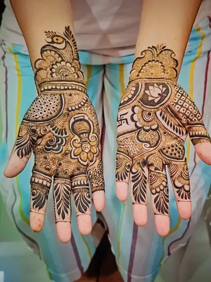 Festive mehandi designed for a special celebration. This custom piece includes auspicious symbols like a kalash (ceremonial pot) and a swastika, blended with traditional peacock and floral patterns.