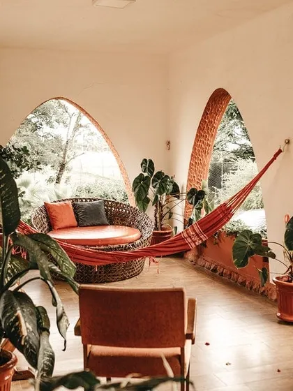 This room features warm, terracotta-colored paint on the walls and arched window frames, creating a bohemian and earthy vibe. I can work with unique architectural features.