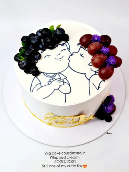 A creative and cute anniversary cake from 2020, using fresh grapes to create the "hair" for the illustrated couple.
