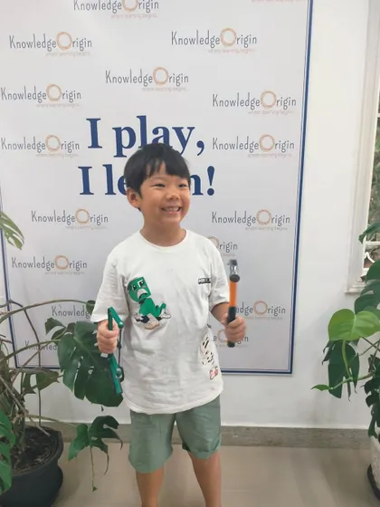 This camper's bright smile says it all. Learning to build things with his own hands is an empowering and joyful experience.