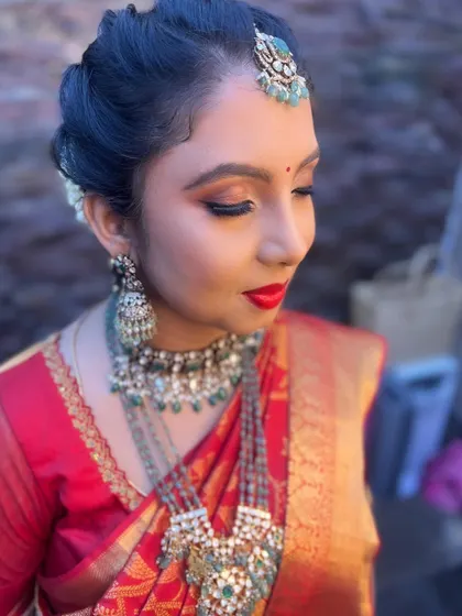 A classic red lip and defined eyes are a perfect match for a traditional red silk saree. This look is timeless, elegant, and photographs beautifully.