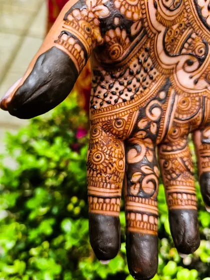 A close-up showcasing the deep, almost black, matured stain on the fingertips and the intricate patterns on the palm. This is the power of my organic henna blend.
