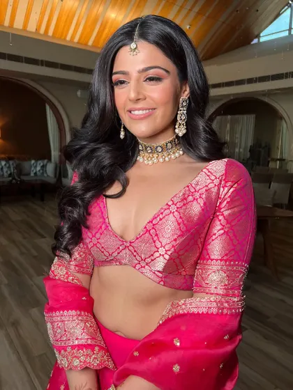 A bride's happy smile is my biggest reward. For this look, I used shades of pink on the eyes and lips to match her vibrant lehenga, creating a fresh and joyful bridal style.