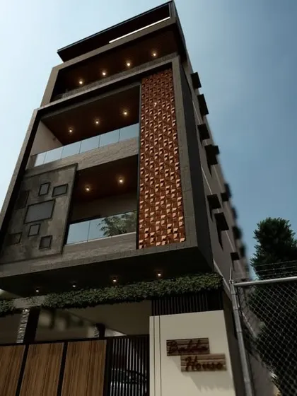 A tall, modern building design featuring intricate jali work on the facade. This element adds a decorative touch while also providing shade and privacy.