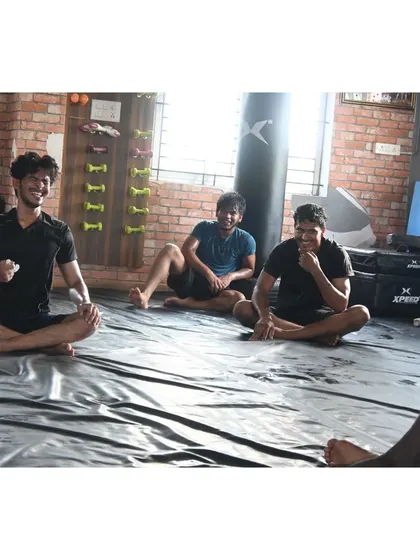 Students resting and listening to the coach between BJJ rolls.