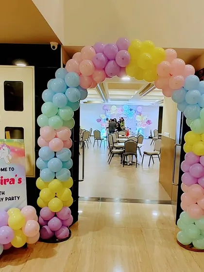 The entrance to Anaira's unicorn party, featuring a beautiful pastel rainbow balloon arch and a personalized welcome sign.