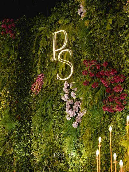 The stage backdrop featured a lush green wall with the couple's monogram in a warm neon light. This created a perfect, personalized photo opportunity for the couple and their guests.