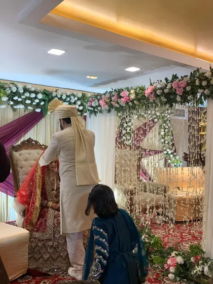 Another shot from the Nikah ceremony, showing the couple and the intricate details of the floral partition and stage decor.