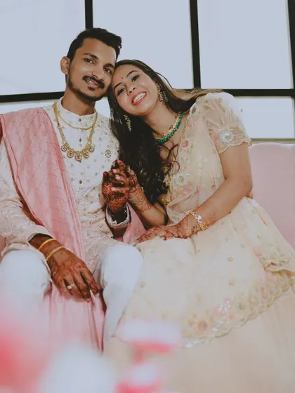 A sweet, seated portrait of the same couple on a pink sofa, showing a softer side.