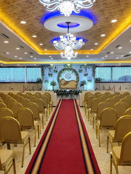 A wide shot of the venue with the floral arch stage.