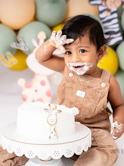 Look at that cheeky, frosting-covered grin! This little cub is having the time of his life at his animal-themed cake smash. Capturing these moments of pure delight is what I do best.