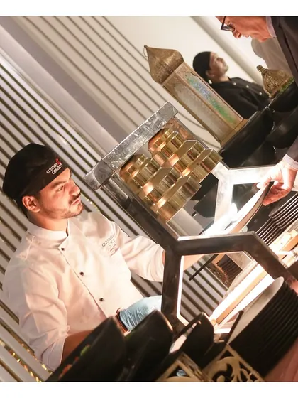 Our unique live station featuring a traditional brass grill, where a chef prepares specialty kebabs for guests.