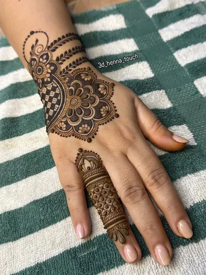 A simple yet elegant back-of-hand design. The central mandala and detailed finger work create a balanced and beautiful look.