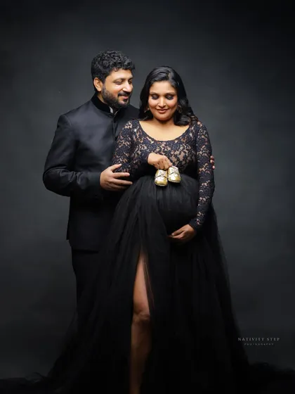 A sweet couple's portrait using tiny baby shoes as a prop. This shot is a classic way to signify the little one on the way.