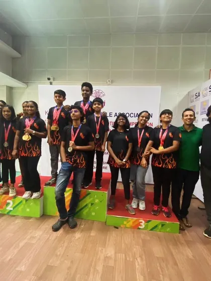 The entire team celebrates a successful run at the Karnataka State Shooting Championship. The camaraderie and shared joy are as important as the medals.