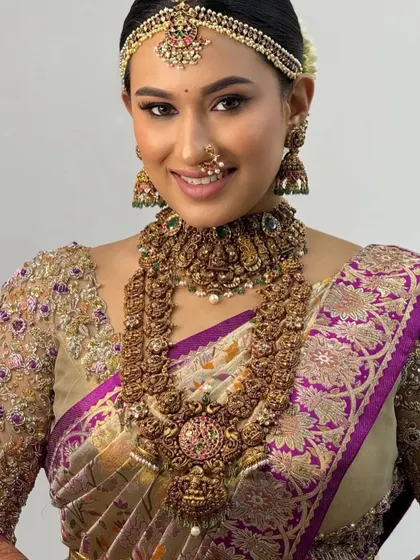 A close-up of the bride's radiant face. Her custom-designed blouse with delicate embroidery frames her beautifully, enhancing her natural glow.