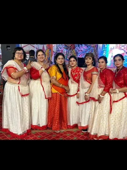 Our ladies' performance group ready backstage in their stunning red and white costumes for a Dandiya night. We coordinate outfits to create a visually spectacular show.