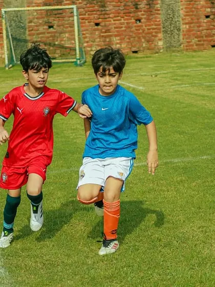 Two young players battling for the ball during a U8 Pride Cup match. We encourage healthy competition and determination.