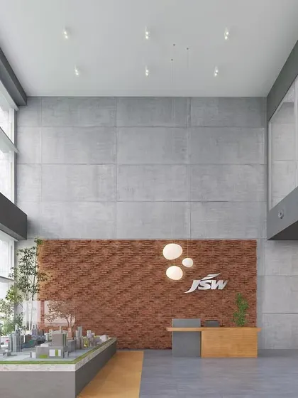 The reception area at JSW Nagaur features a double-height ceiling and a feature wall made of local brick. The design creates a grand sense of arrival while staying rooted in the regional context.